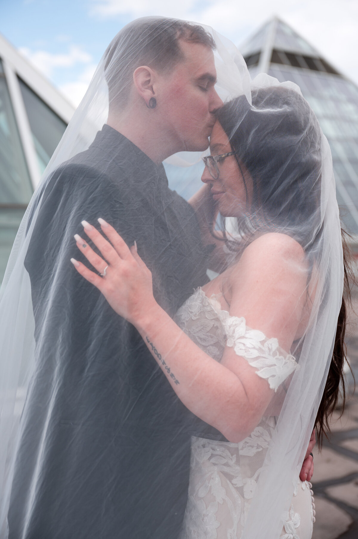 bride and groom underneith veil for a documentary style wedding portrait