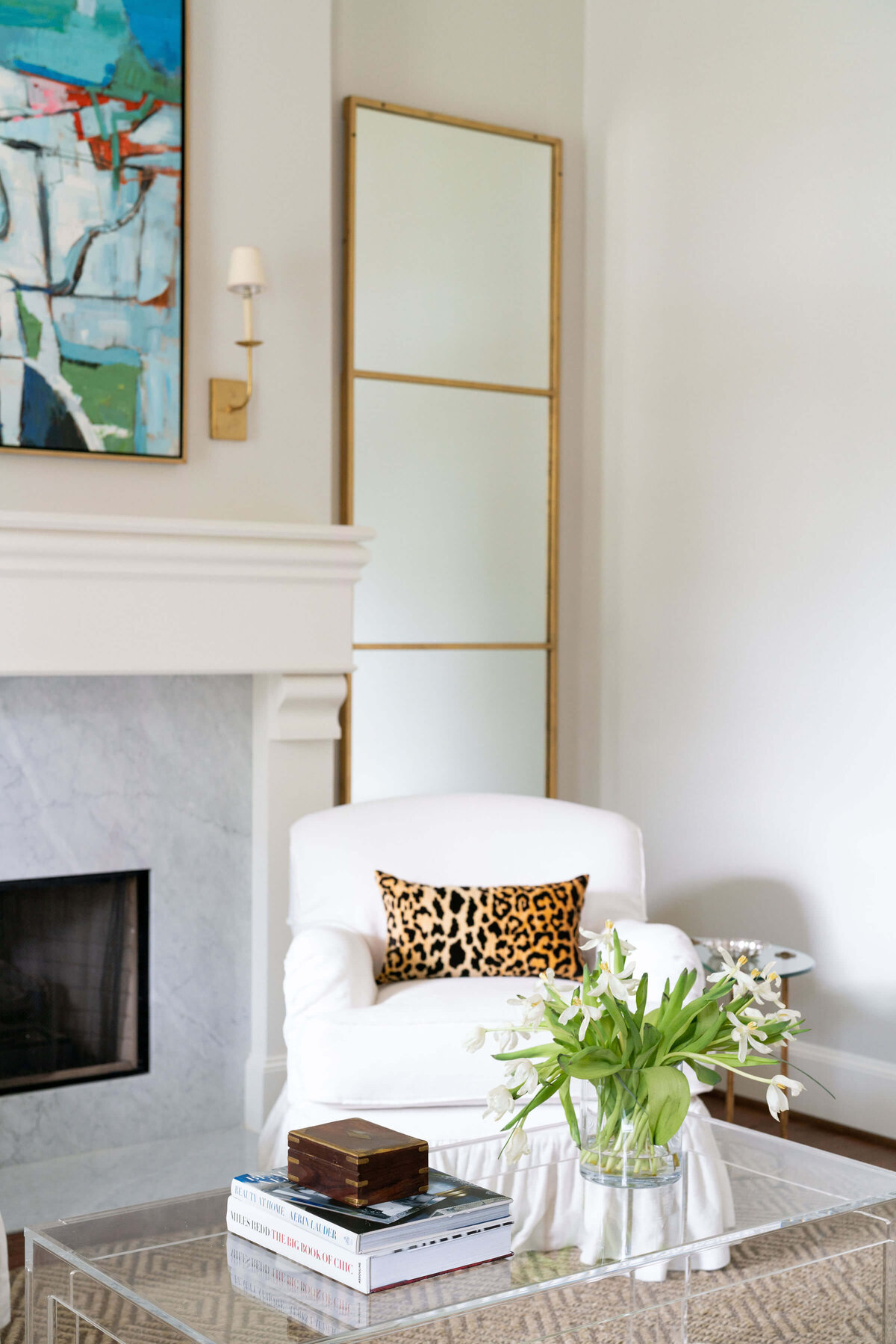 oyster creek studios heathcott leopard print pillow on white armchair next to fireplace in living room