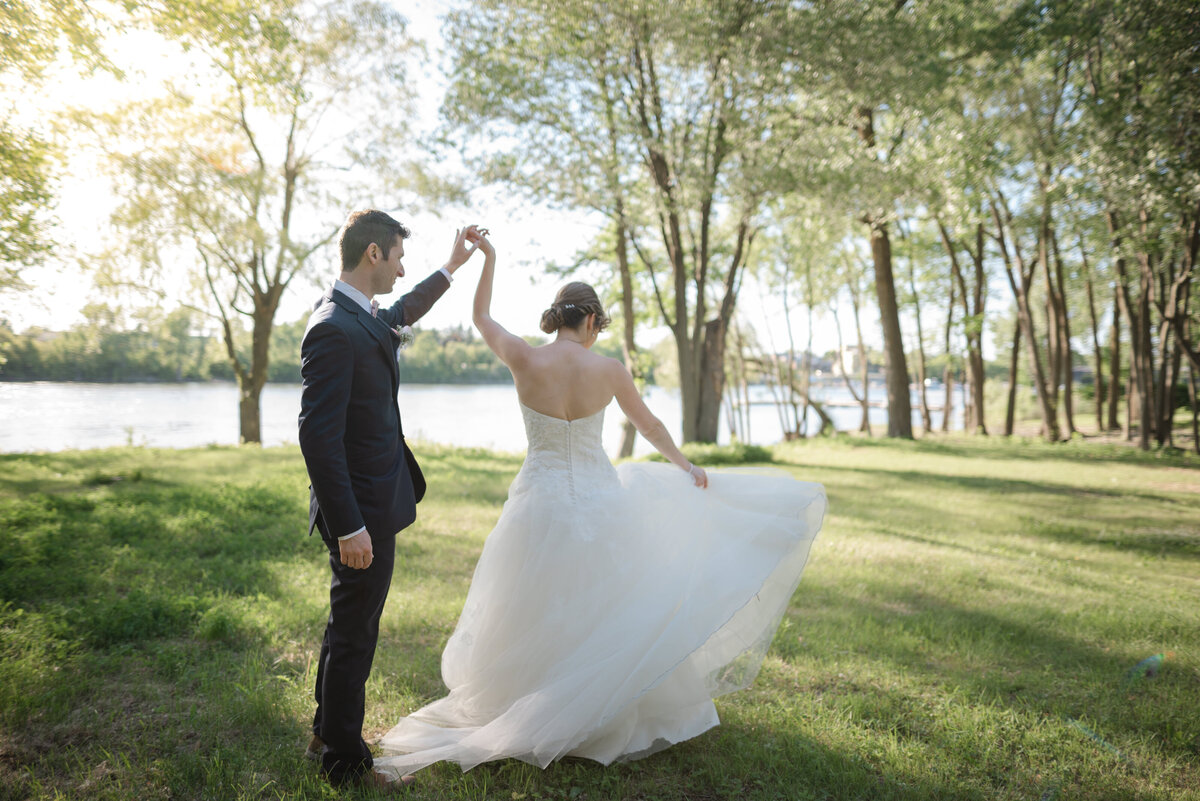 Avec la rivière Richelieu en toile de fond, l’homme fait tournoyer sa femme dans une danse nuptiale empreinte de douceur, sous un merveilleux soleil couchant en Montérégie, capturant un moment magique et lumineux