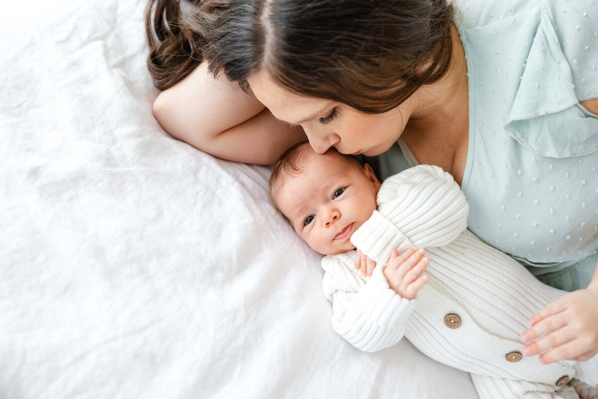 mother-kissing-newborn-soft-light-natural-bend-oregon