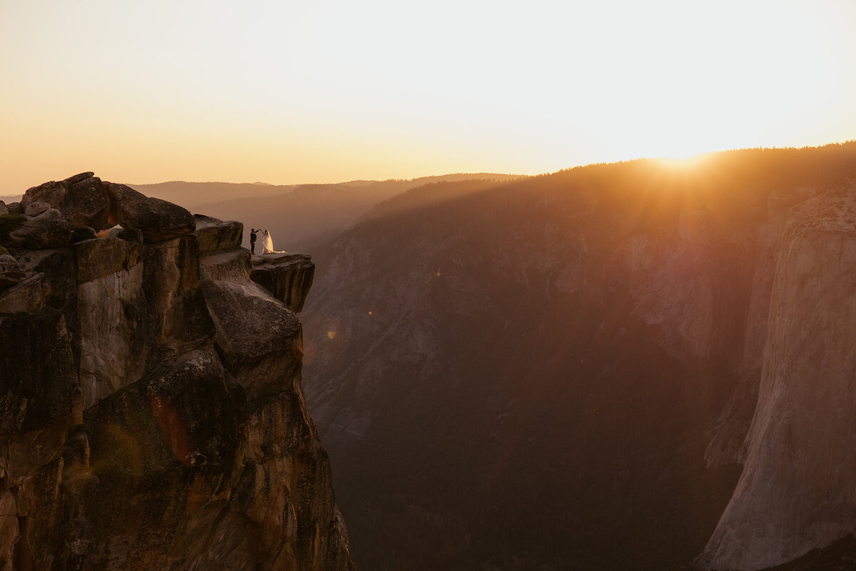 Bride and groom standing at Taft Point in Yosemite on their elopement day