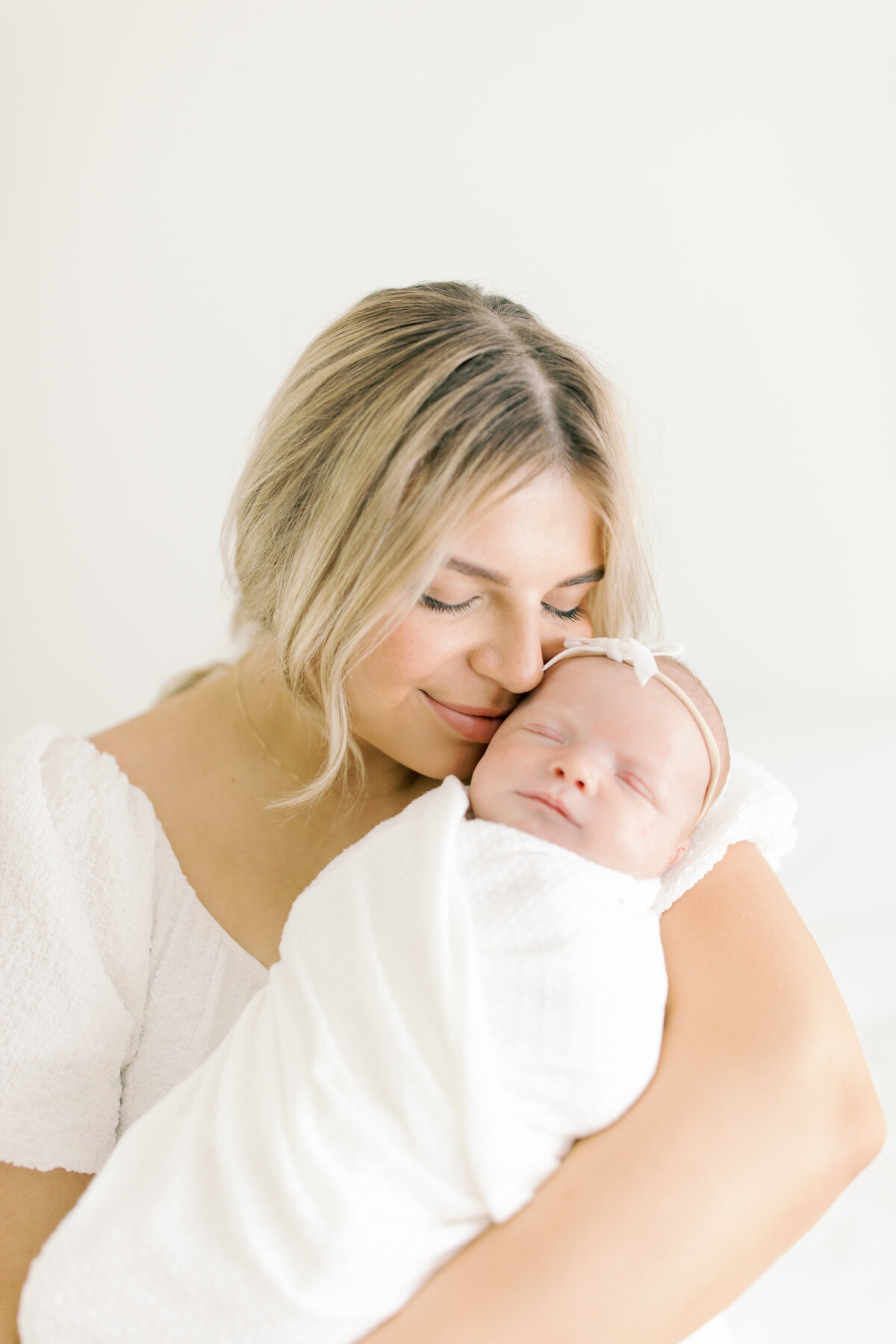 mom holding newborn baby by spokane photographer