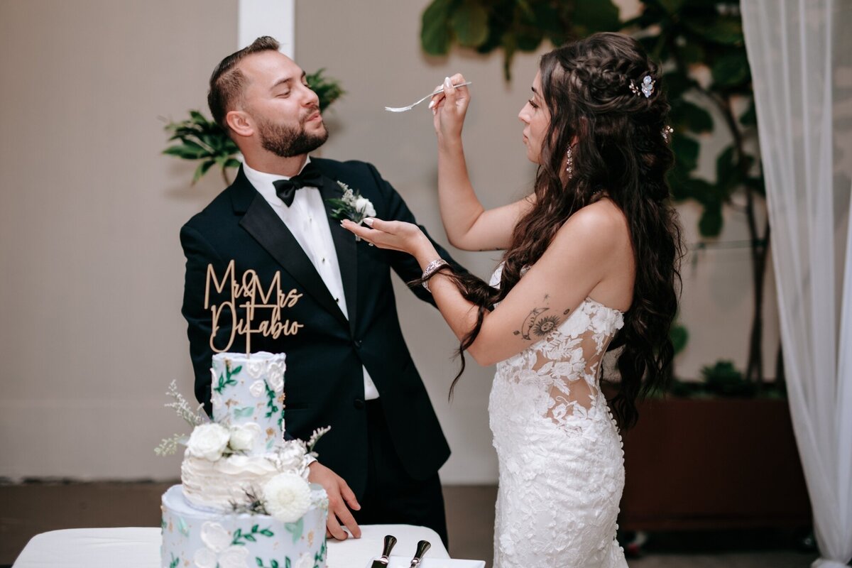 Bride feeding the Groom a piece of cake during their cake cutting.