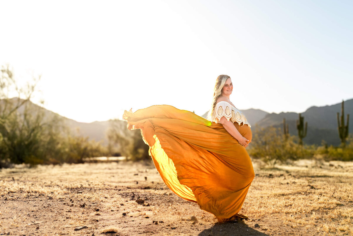 Portrait of a beautiful expecting mom in long, flowing boho gown. Captured by Cactus & Pine Photography