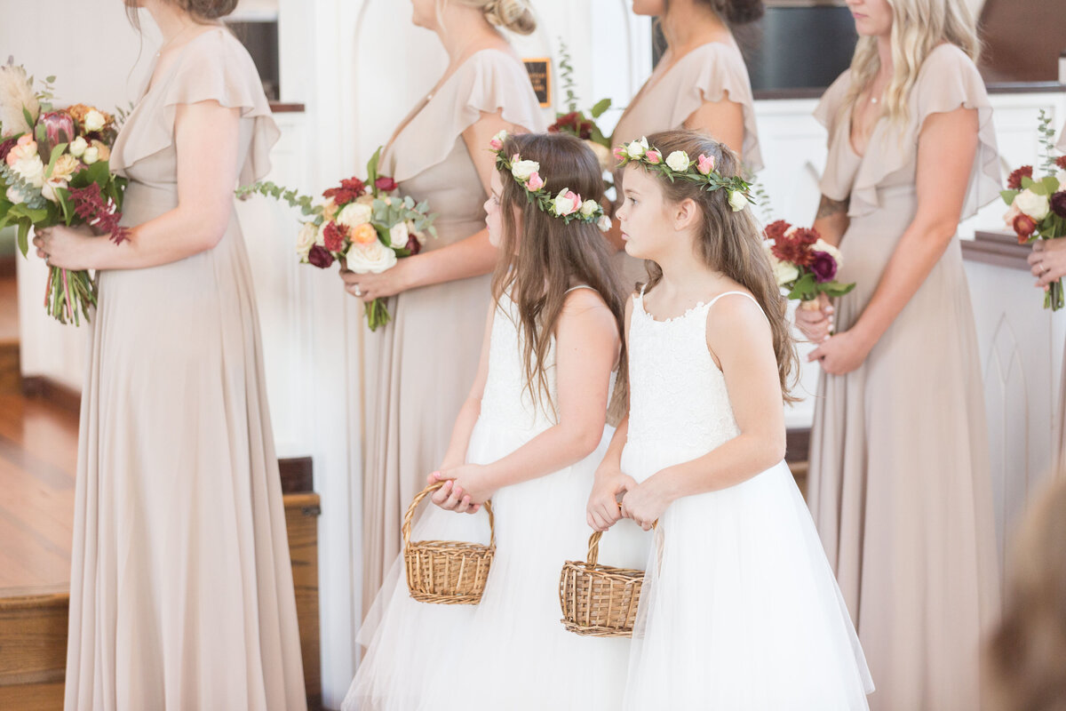 The flower girls watch the wedding ceremony at St. Francis at The Point in Point Clear, Alabama.