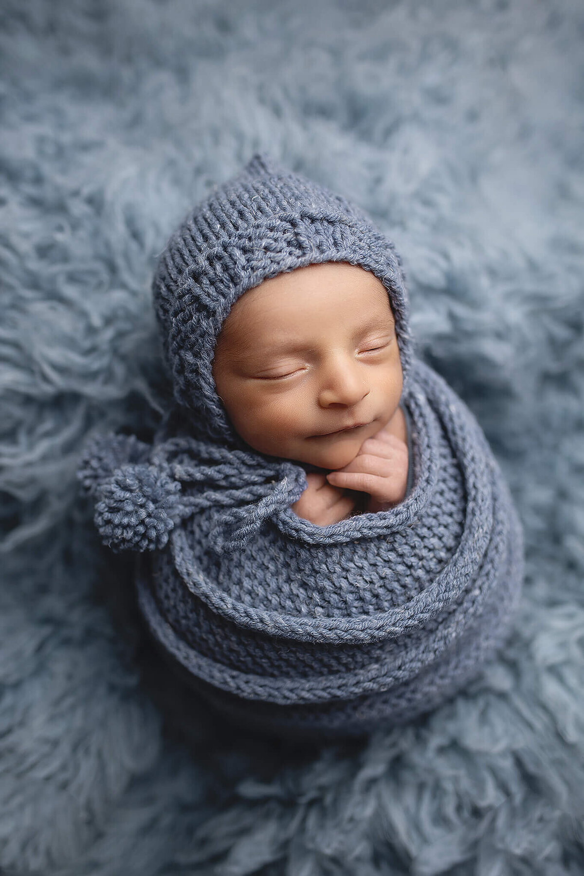 Baby boy wrapped in a soft blue color for his newborn session in New Ulm, Minnesota.
