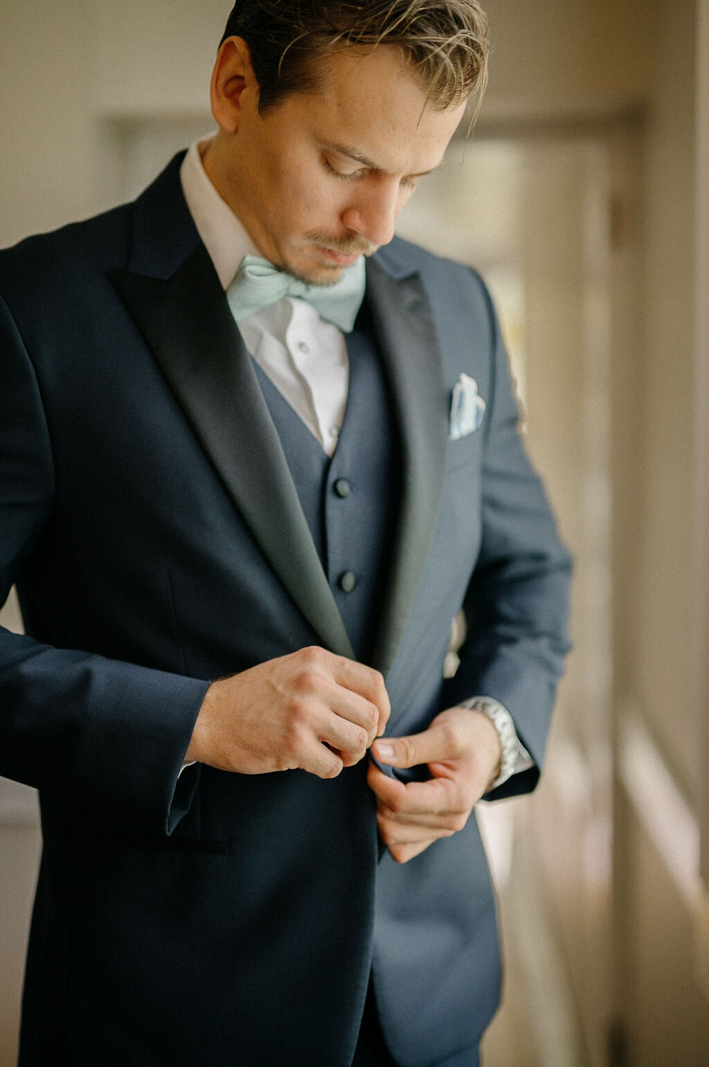 Groom fixing his black suite