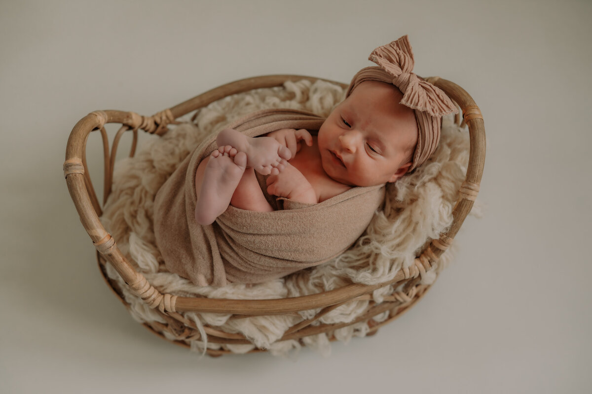 Newborn baby gewikkeld in een wrap voor de newbornshoot.