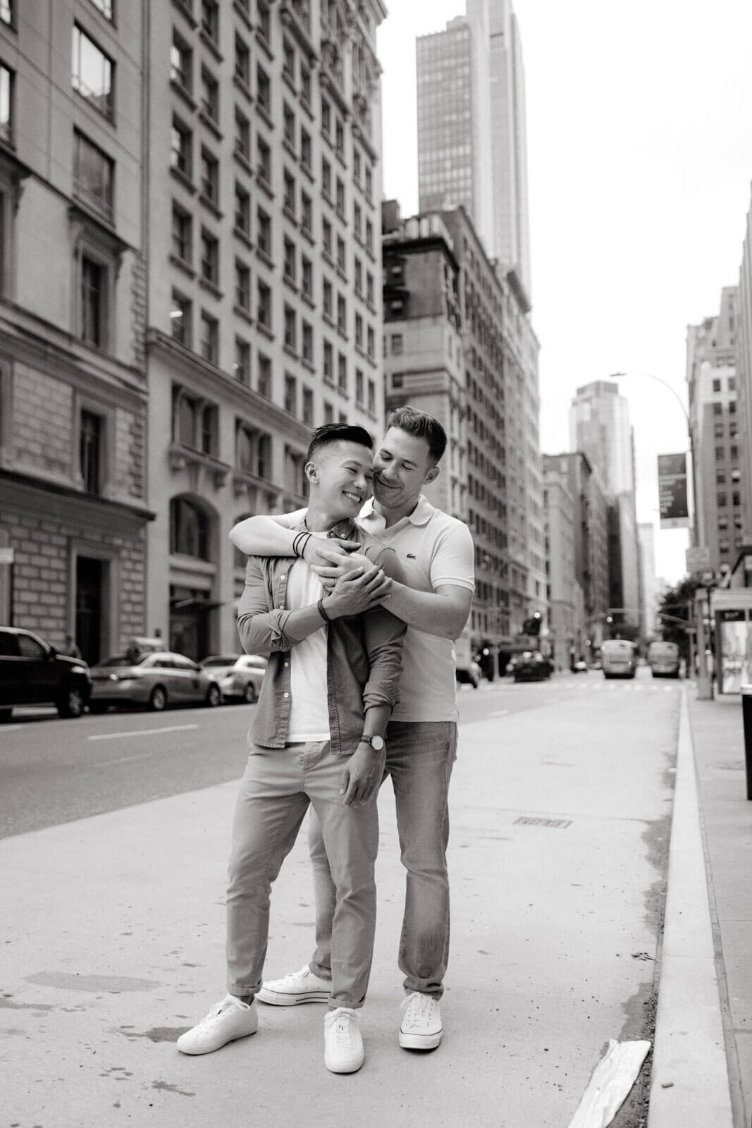 Black and white photo of the engaged man hugging his fiancé from the back, in West Village, NYC. Image by Jenny Fu Studio.