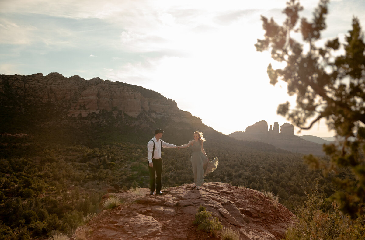 Couple standing against red rock backdrop during Sedona engagement session