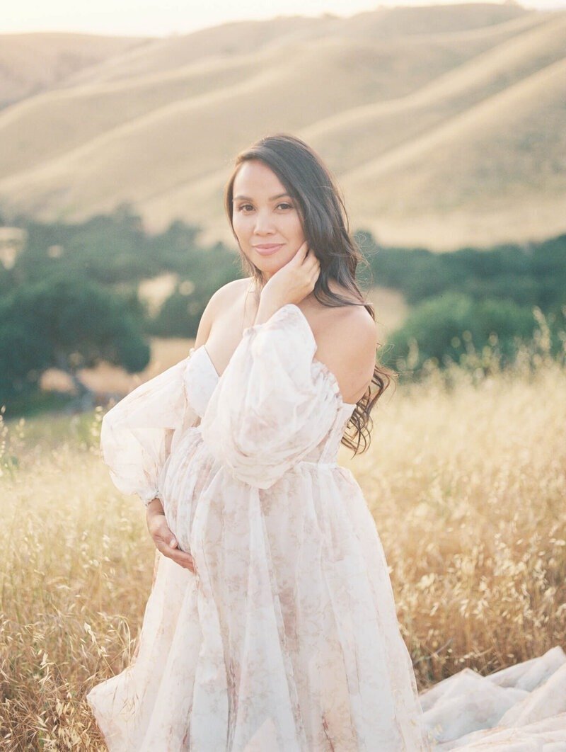 Pregnant woman framing her belly in a tulle dress taken by San Francisco Maternity Photographer Laurel Smith.
