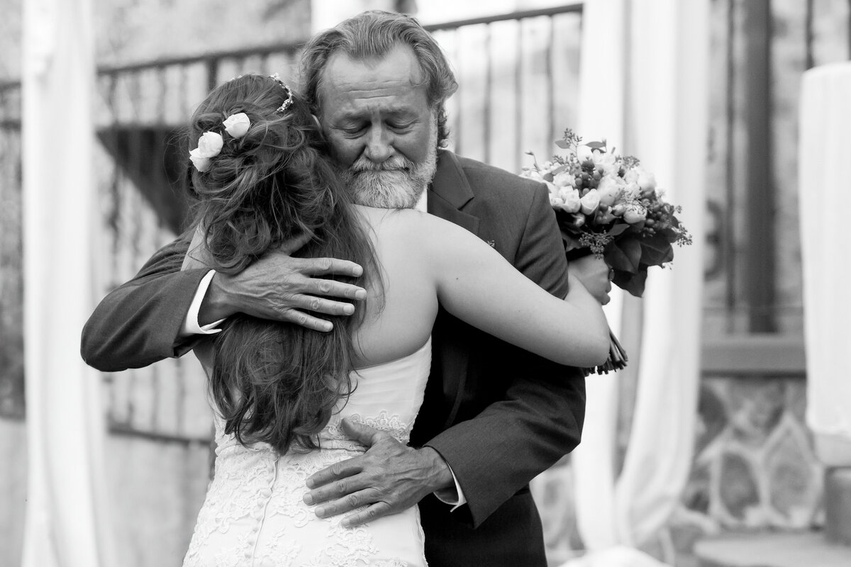 a dad hugs his daughter on his wedding day