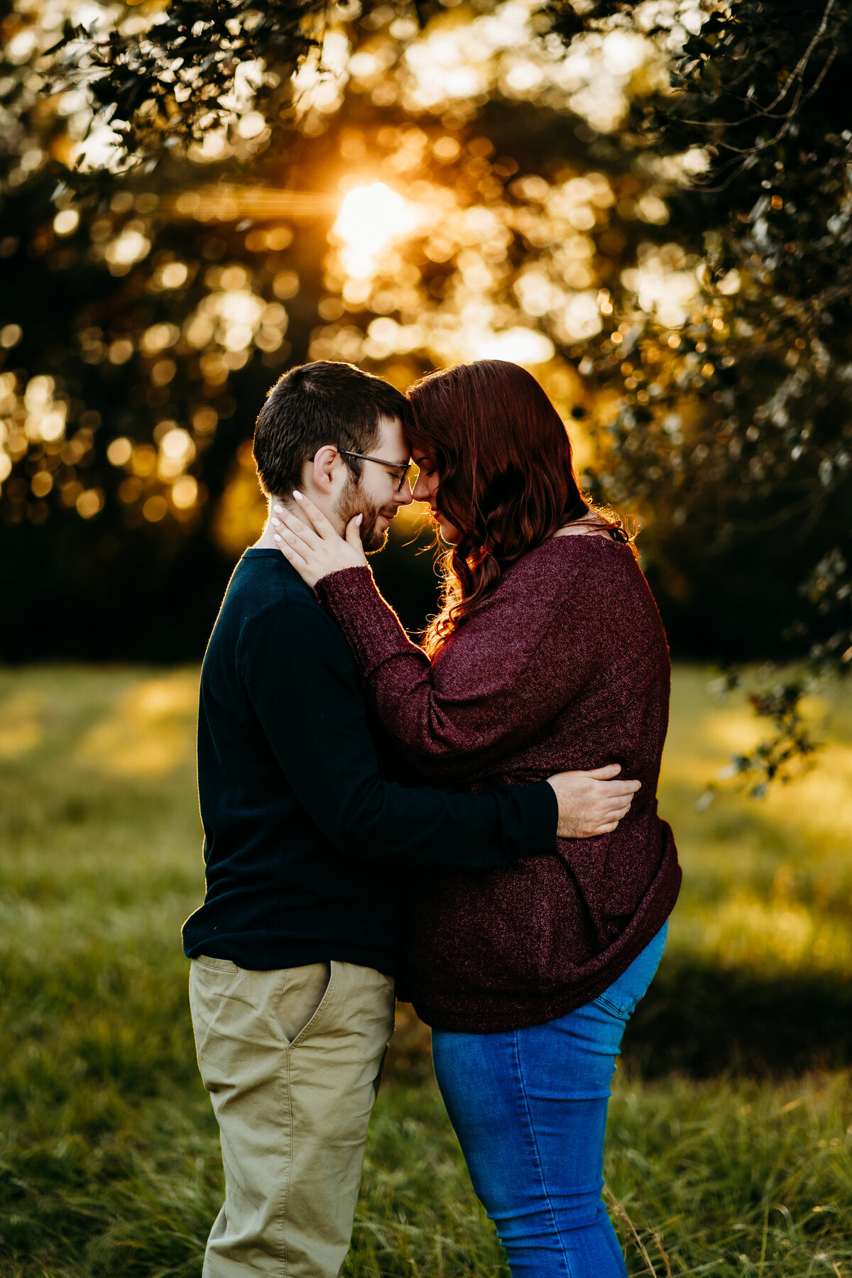 candid engagement photo of couple cuddling in field at sunset in Lafayette, la