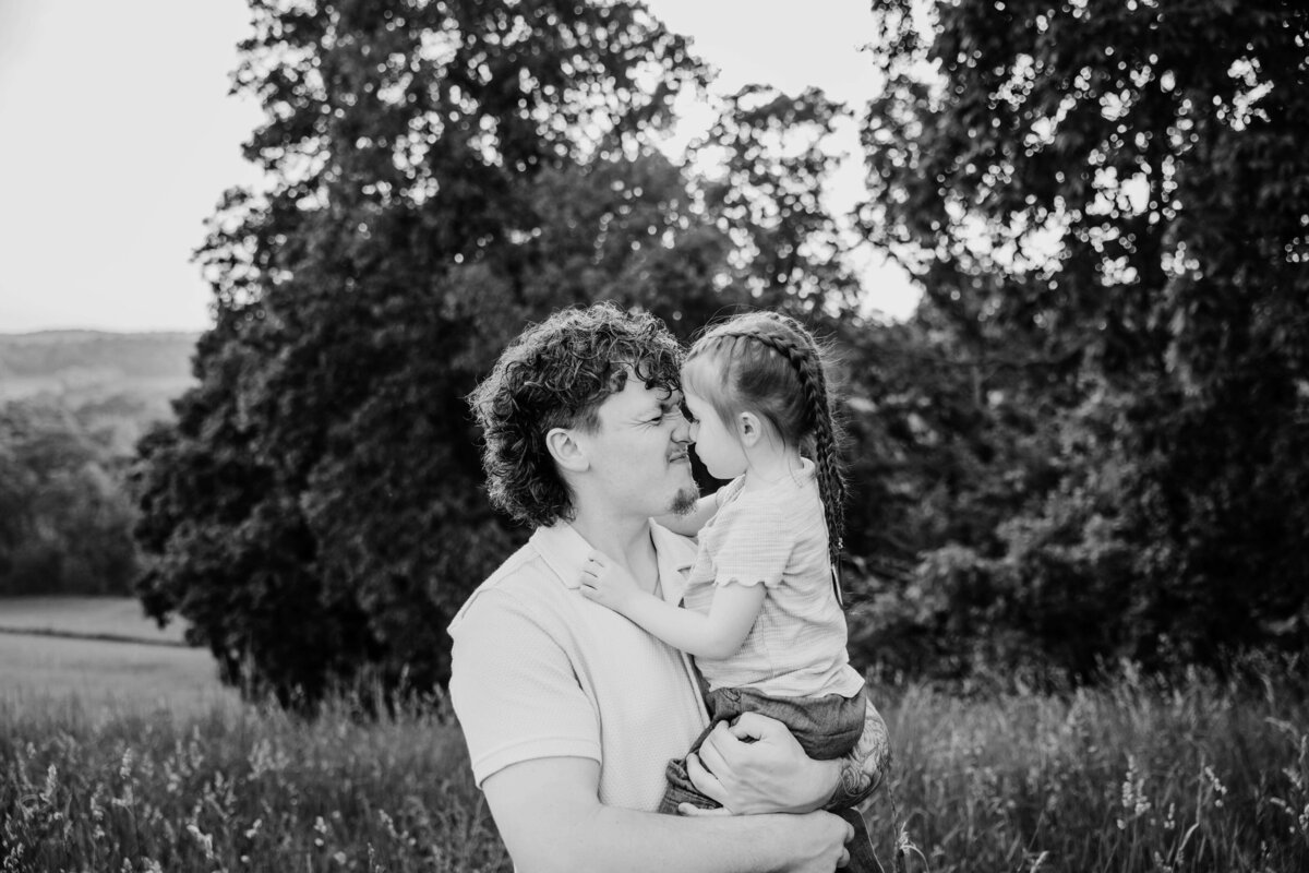 dad holding daughter giving eskimo kiss in session with reva davis photography