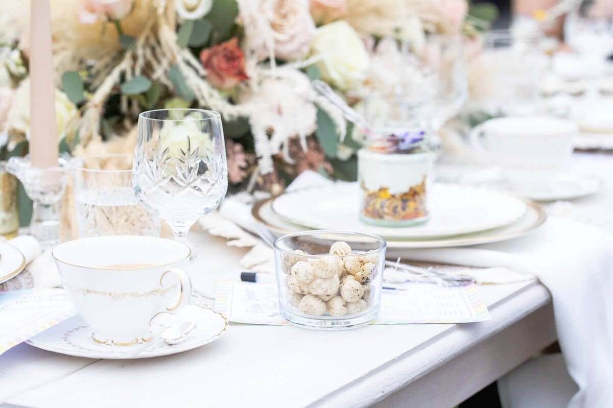 Vintage table setting for afternoon tea, gold rimmed plate with mini desserts