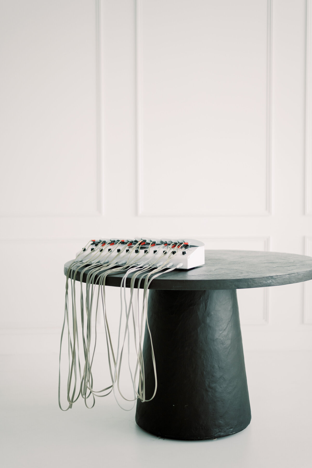 Modern black round table with medical aesthetic equipment for body contouring
