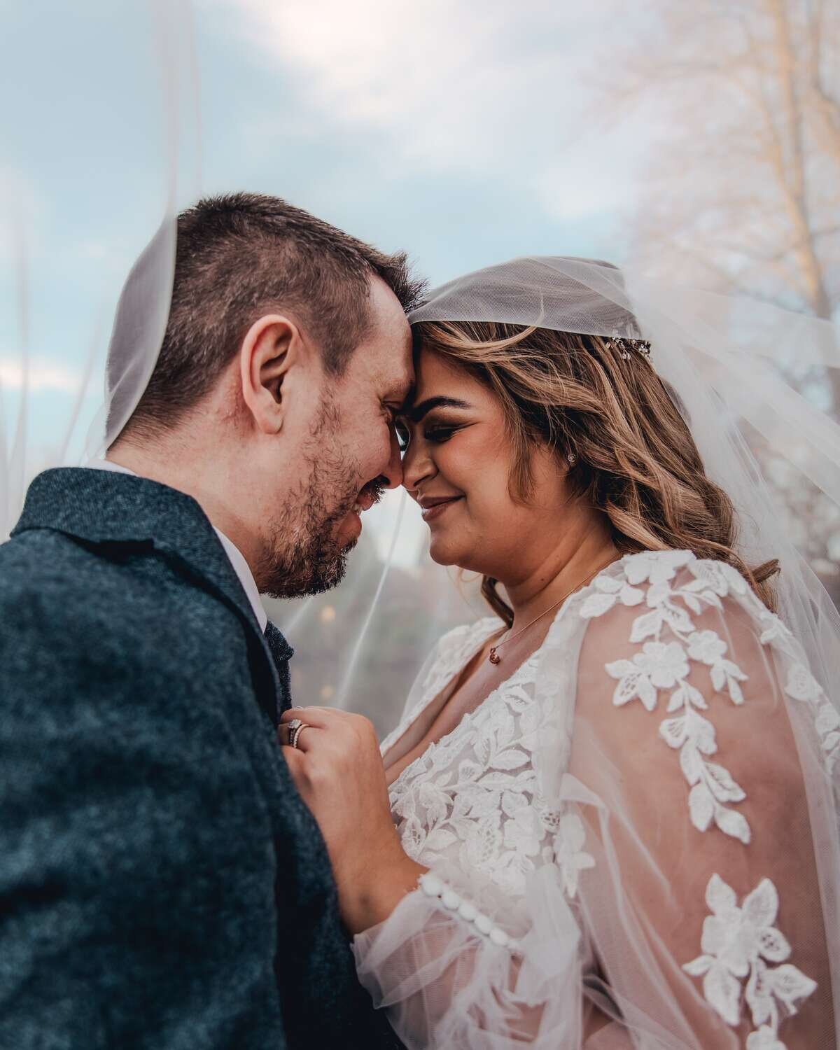 Bride and Groom touch foreheads together and embrace lovingly