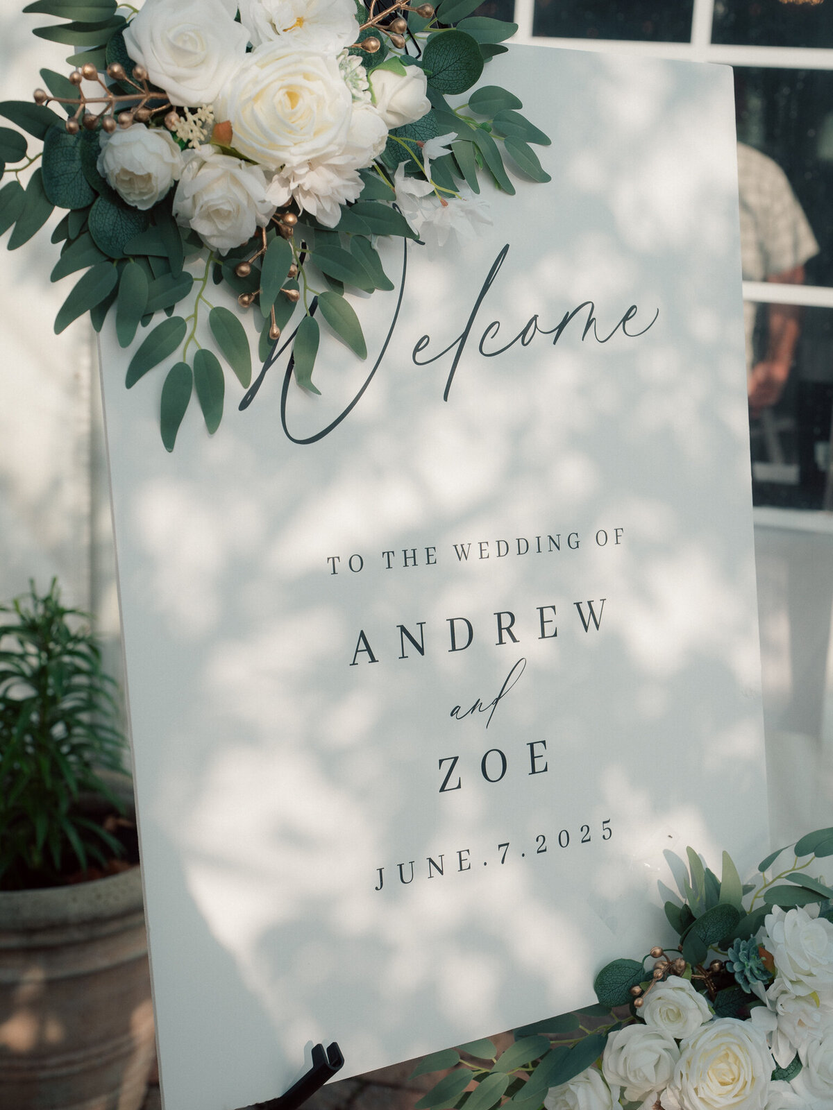Wedding welcome sign with white roses and greenery