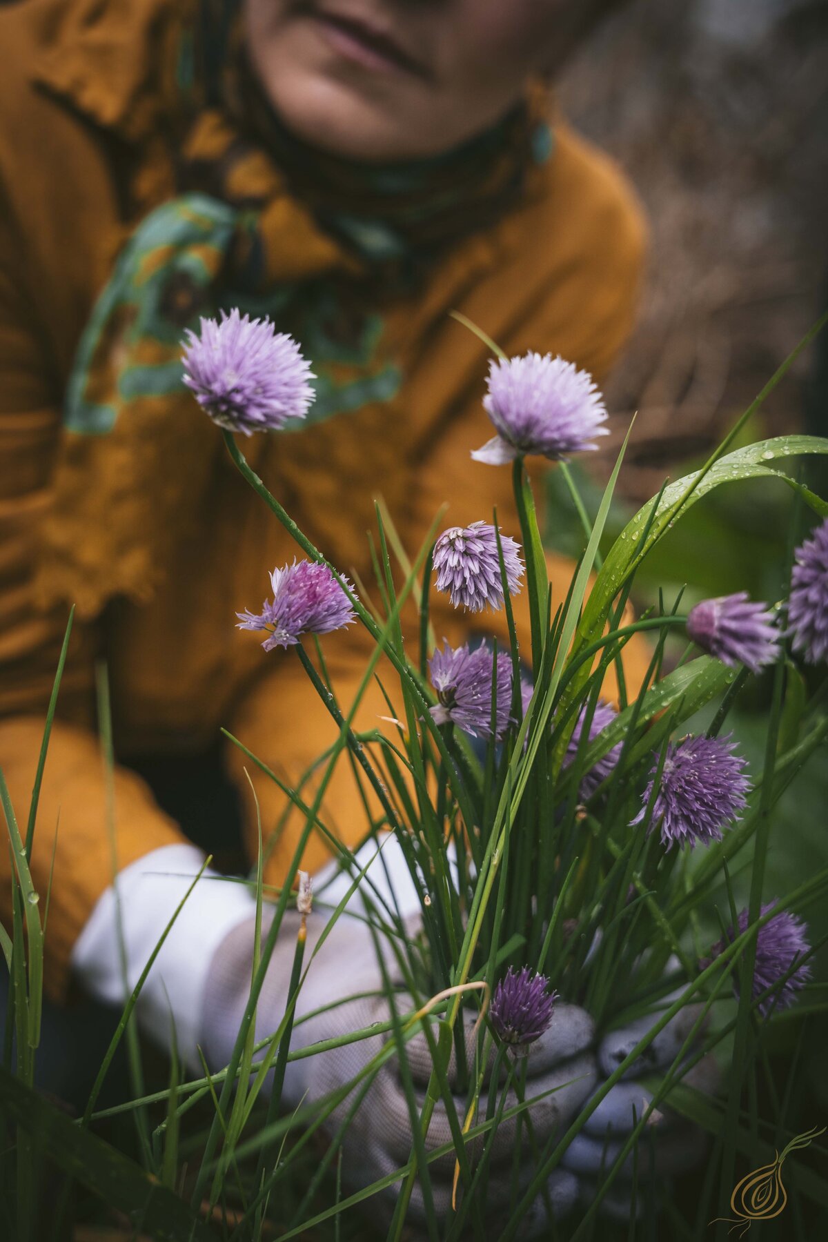 A woman kneels gracefully, holding a vibrant bouquet of flowers in her hands, showcasing nature's beauty.