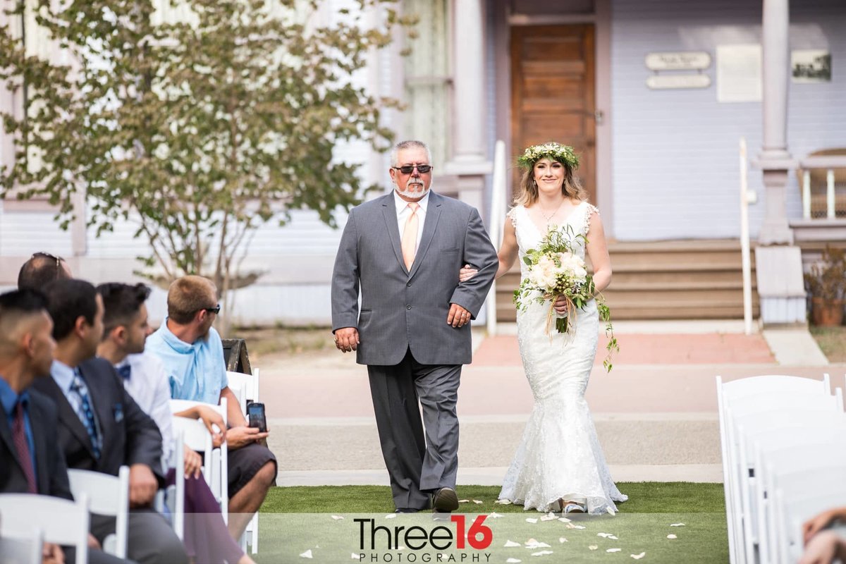 Bride is escorted up the aisle by her father