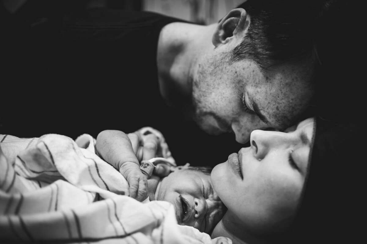 a couple and their newborn baby moments after his birth
