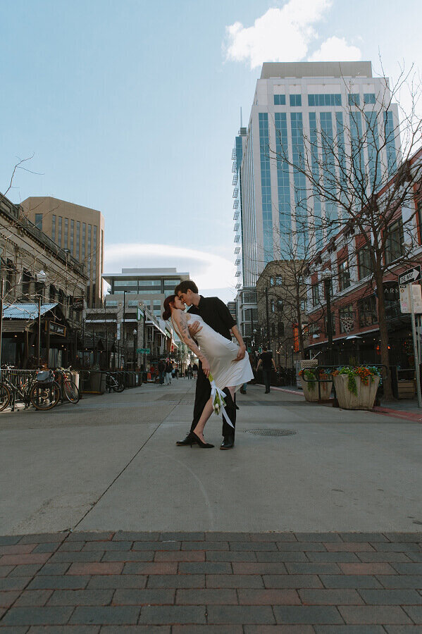 A man dips his new wife in downtown Boise on their elopement wedding day.