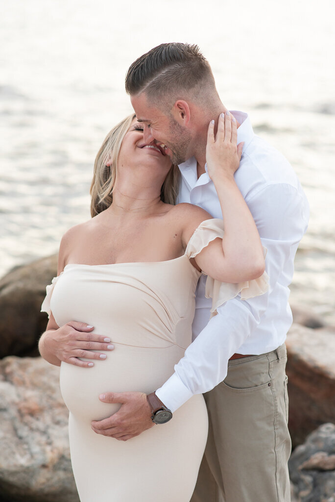 Pregnant mom and dad kissing in dress on the beach |Sharon Leger Photography || Canton, CT || Family & Newborn Photographer