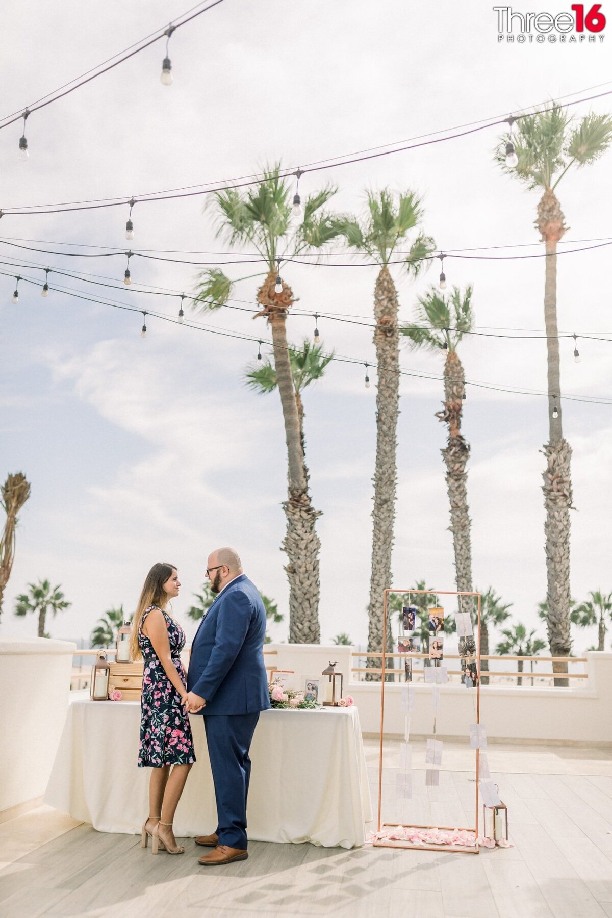 Engaged couple hold hands and stare at each other during a Hilton Waterfront Resort engagement session.