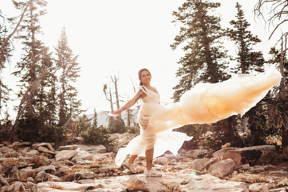 Bride tossing her dress in the mountains