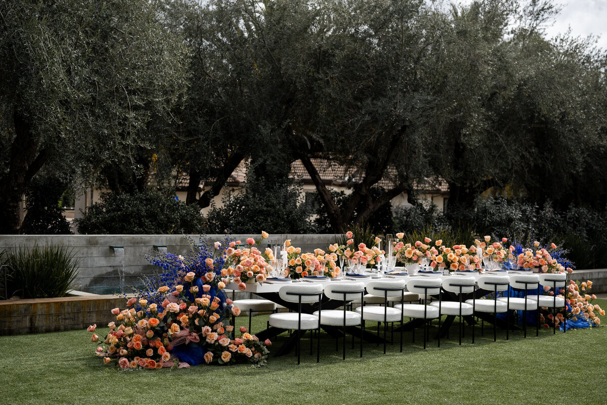 San Francisco Bay Area wedding photographer showcases dramatic floral installation with orange and blue arrangements creating stunning ceremony backdrop at Estate Yountville in Napa Valley