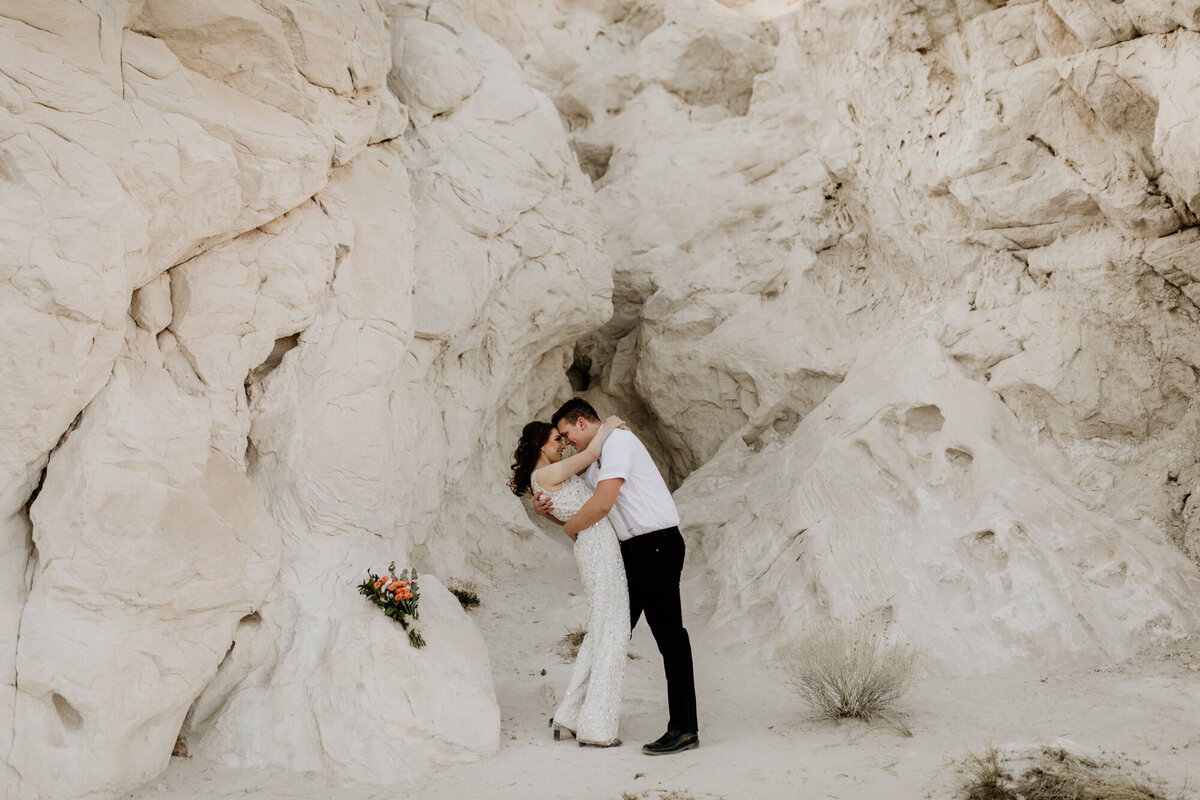groom dipping bride in front of a NM white rock canyon