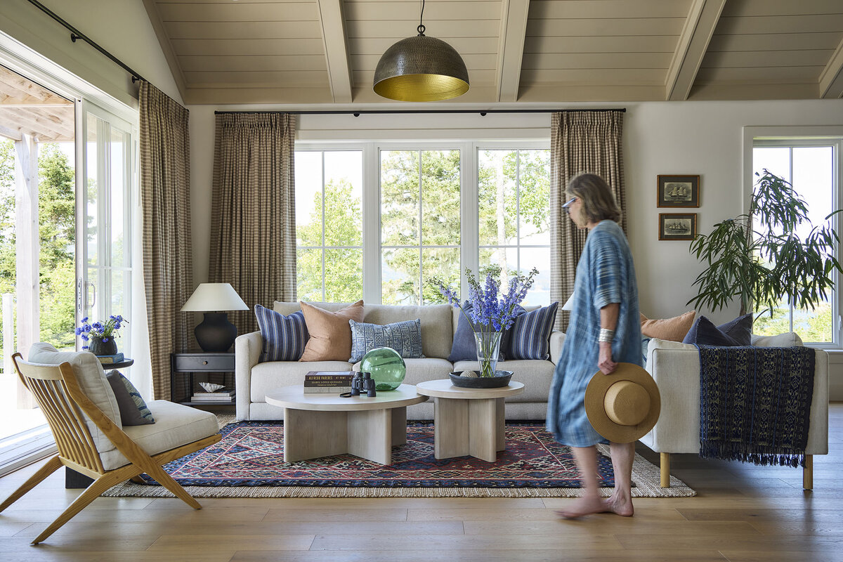 Living room interior design in a bright room with lots of windows. The overall feeling is cozy.
