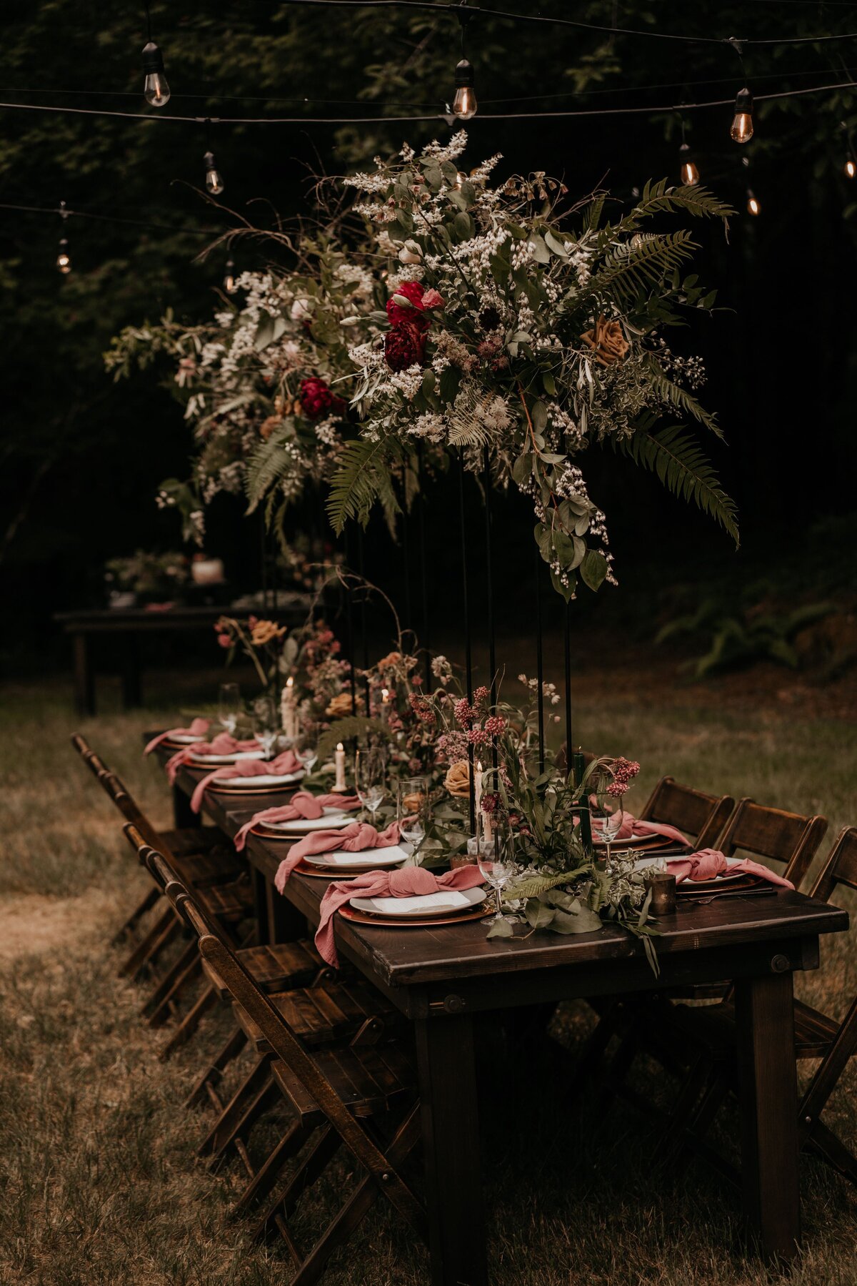 Moody elopement tablescape with meadow-style floral runner and wild arrangements on tall stands!