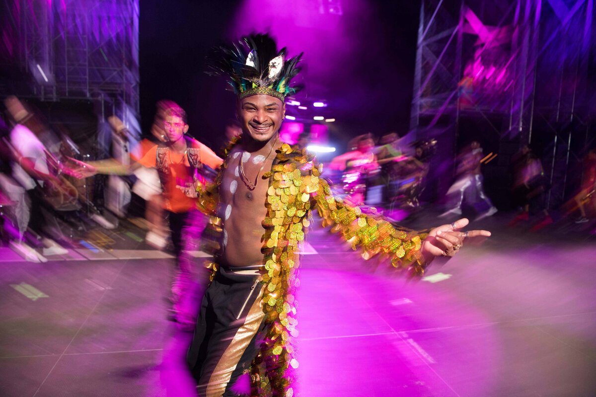 Dancer photographed looking at camera with blurred motion wearing colorful outfit