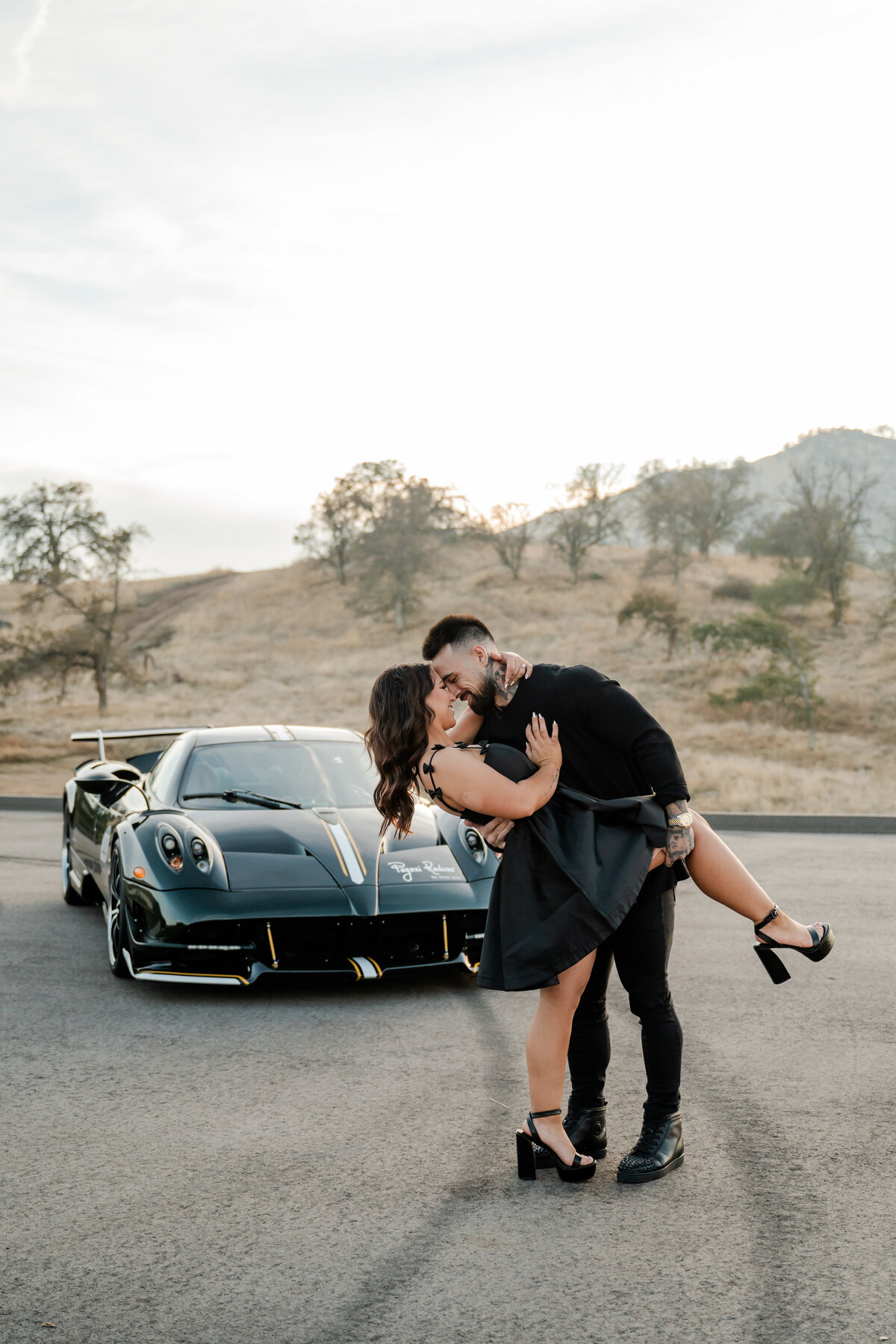 Couple posing by a Pagani during their engagement session.