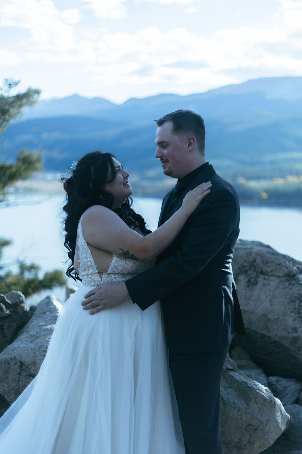 A newlywed couple smiling with their arms around each other.