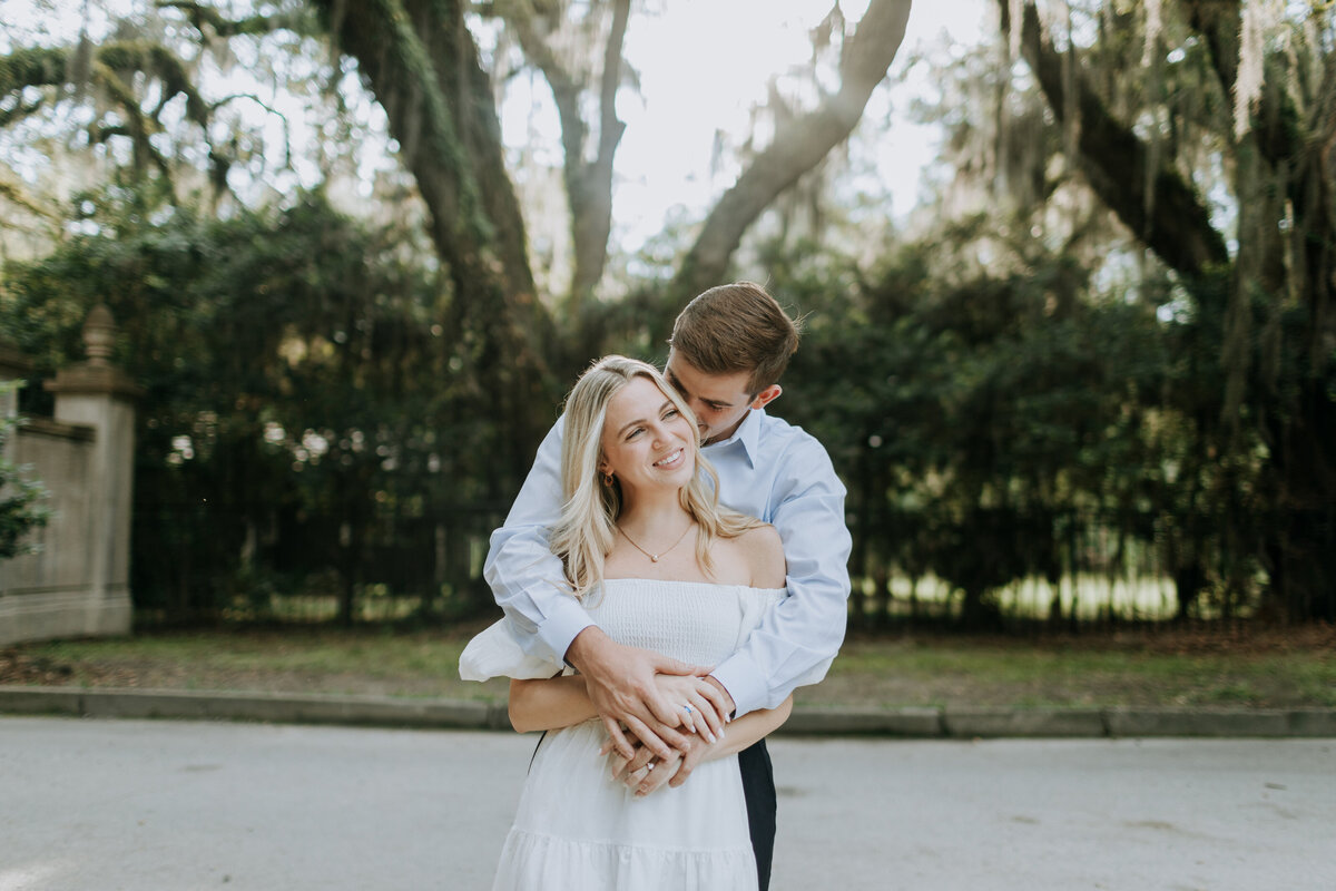 Statesboro weddinWedding photography in Statesboro, GA couple kissing in front of trees draped with Spanish moss.