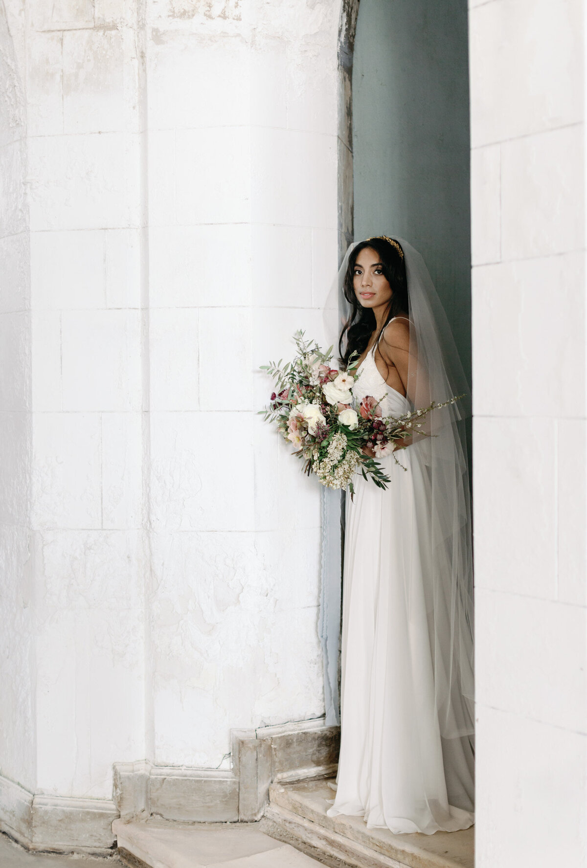 Indian bride with colorful bouquet, ruins wedding venue, Italy film wedding photographer