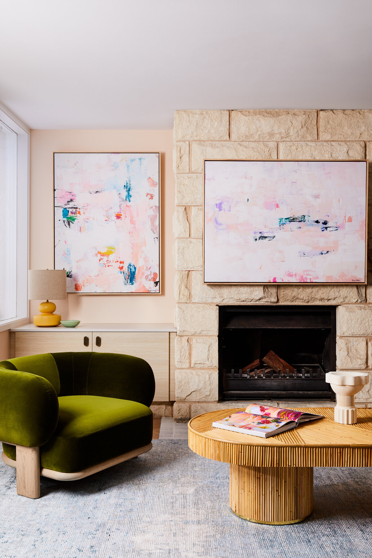 A living room in Sandringham, Melbourne, featuring a stone fireplace and a large colorful abstract painting hanging above a light wood and stone console cabinet.