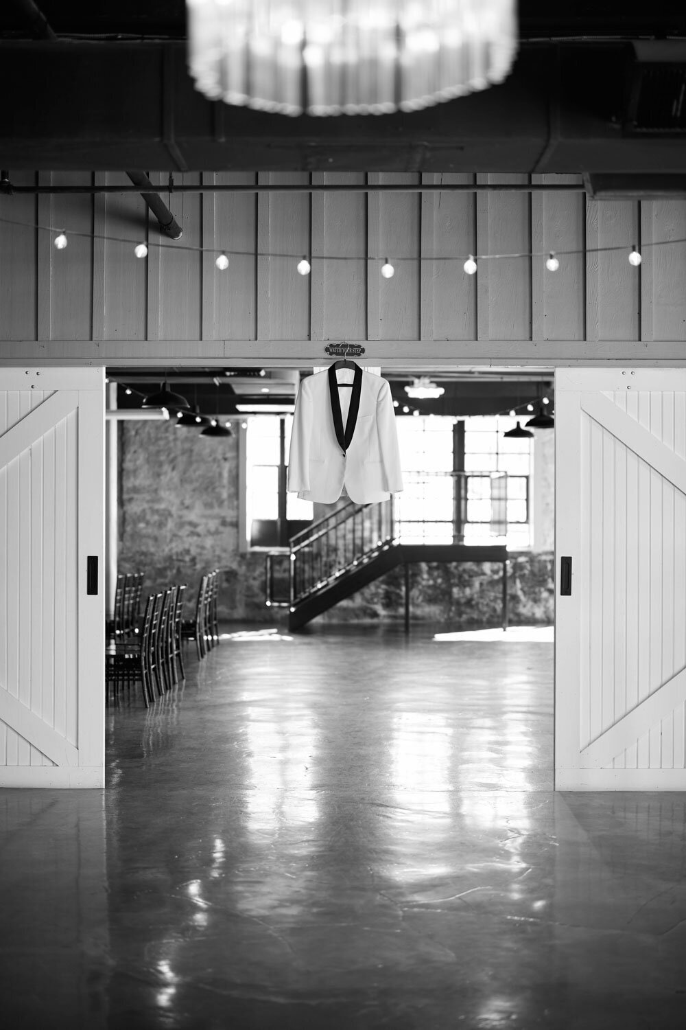 White suite of groom hanging in the reception entrance