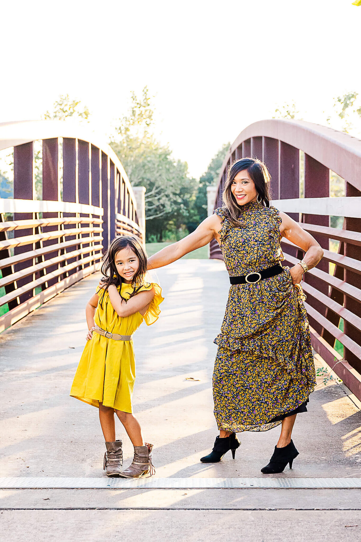 Mom and daughter posing on a bridge