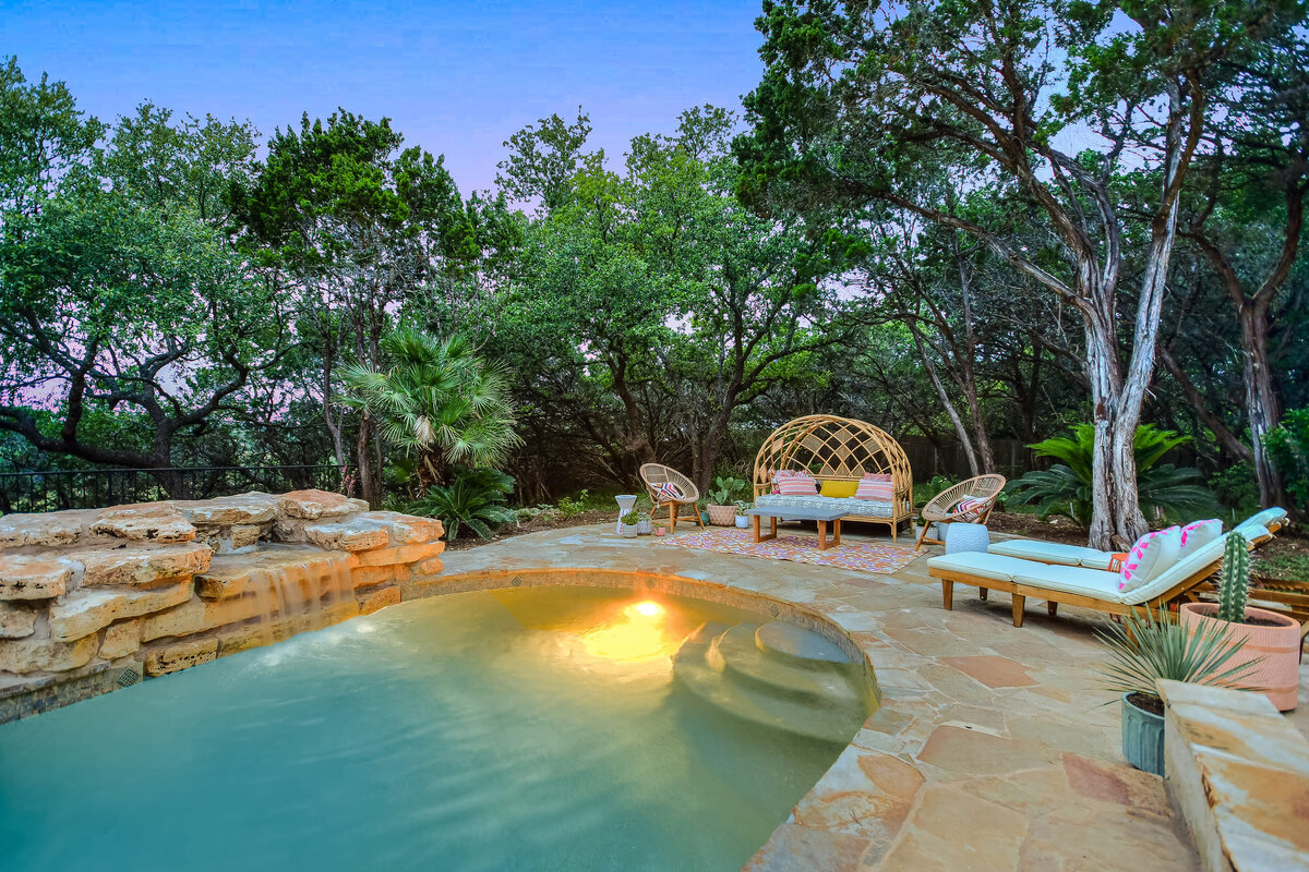 Waterfall at an exterior pool with sunbeds