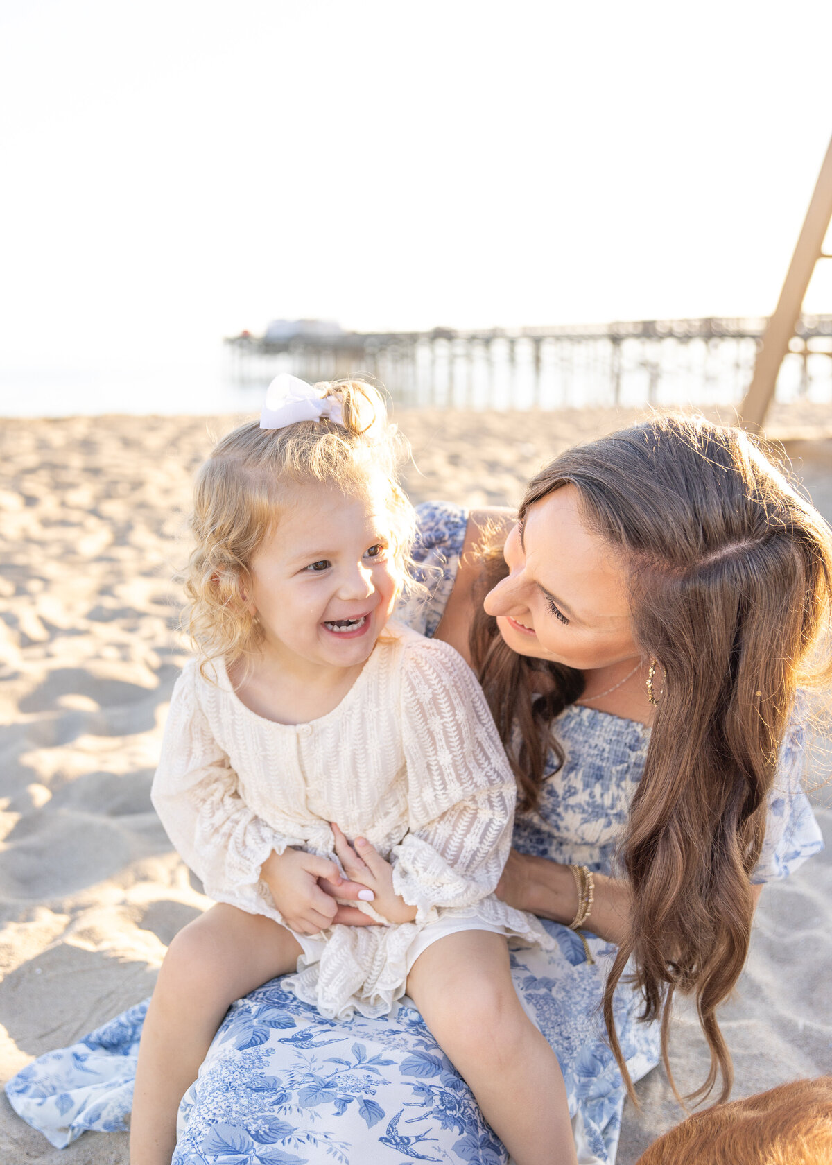mother and daughter laughing together on the beach