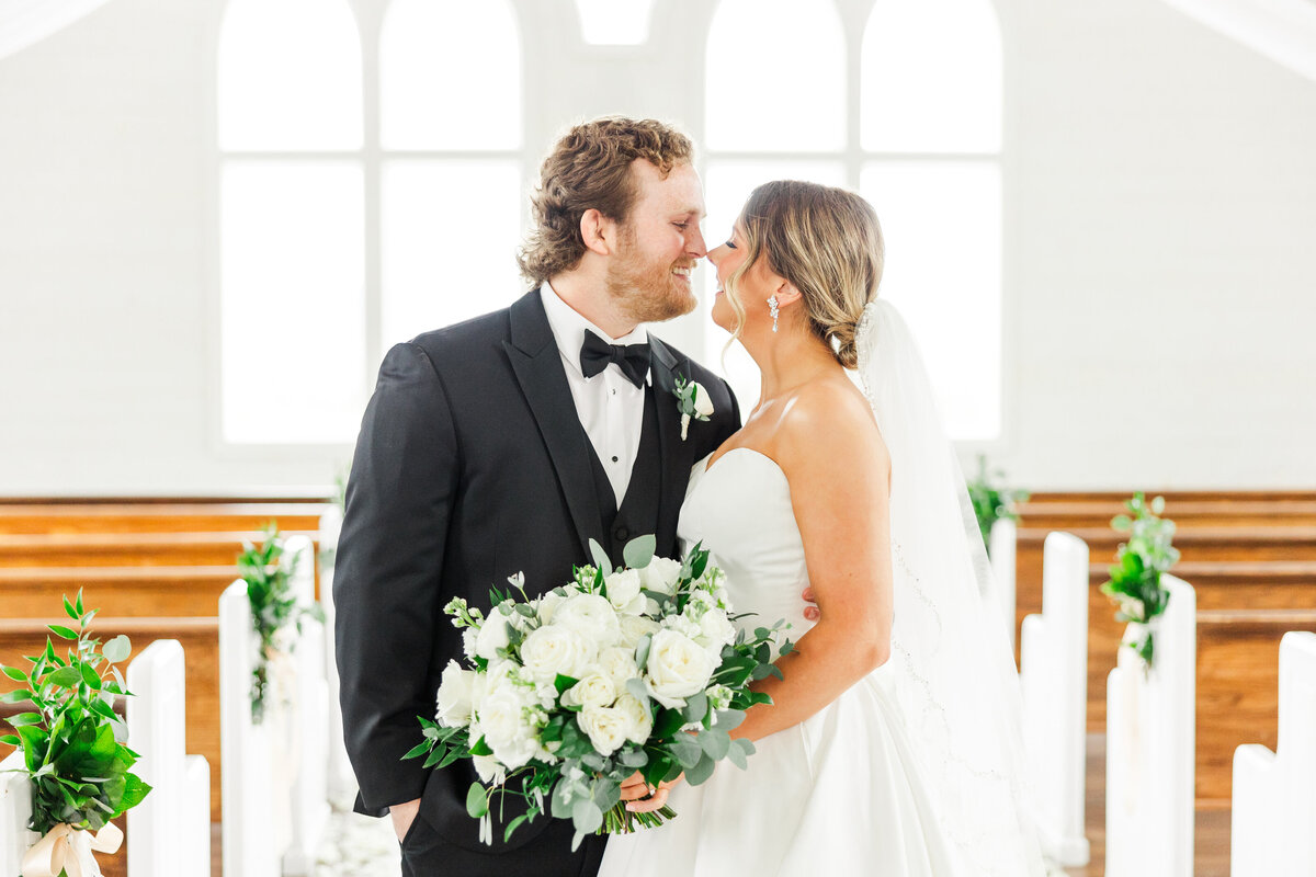 a bride and groom about to kiss inside a wedding chapel