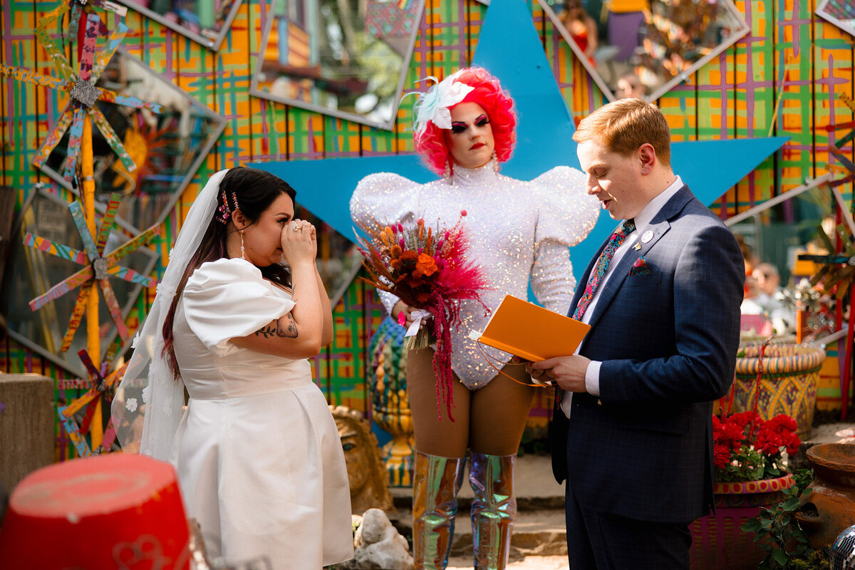 bride-and-groom-getting-married-drag-officiant-colorful-setting