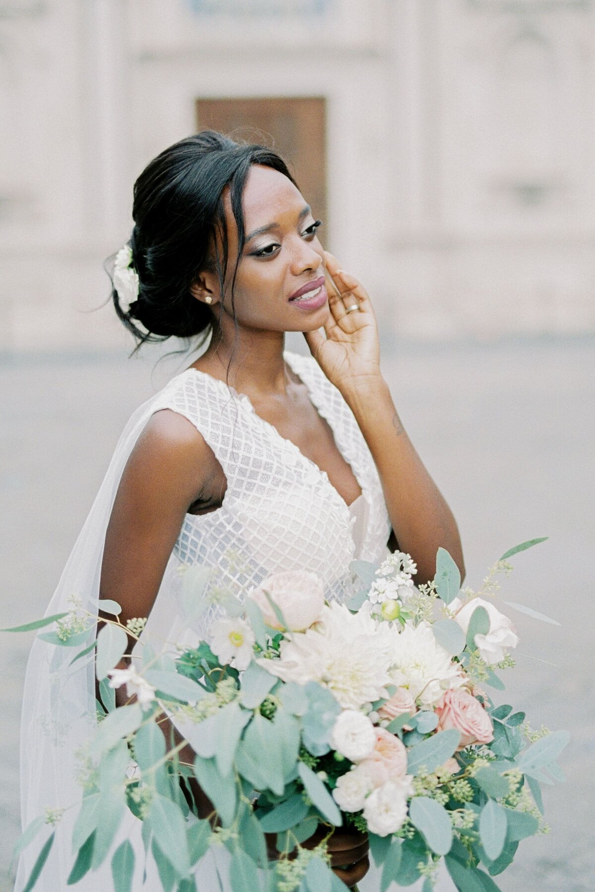 bride-white-dress-with-bouquet-touches-her-cheek-with-her-fingers