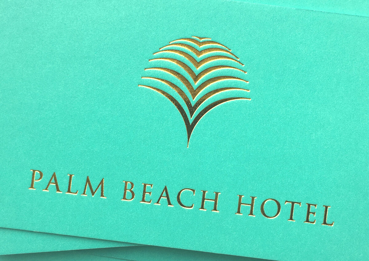 Close up of Palm Beach Hotel  gold foil logo design printed on sea green business card front.