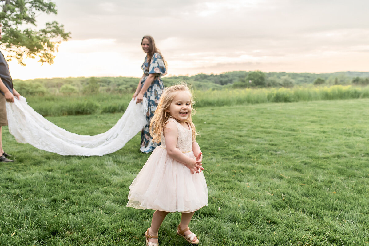 Girl running under blanket thrown by parents at family photo shoot |Sharon Leger Photography | Canton, CT Newborn & Family Photographer