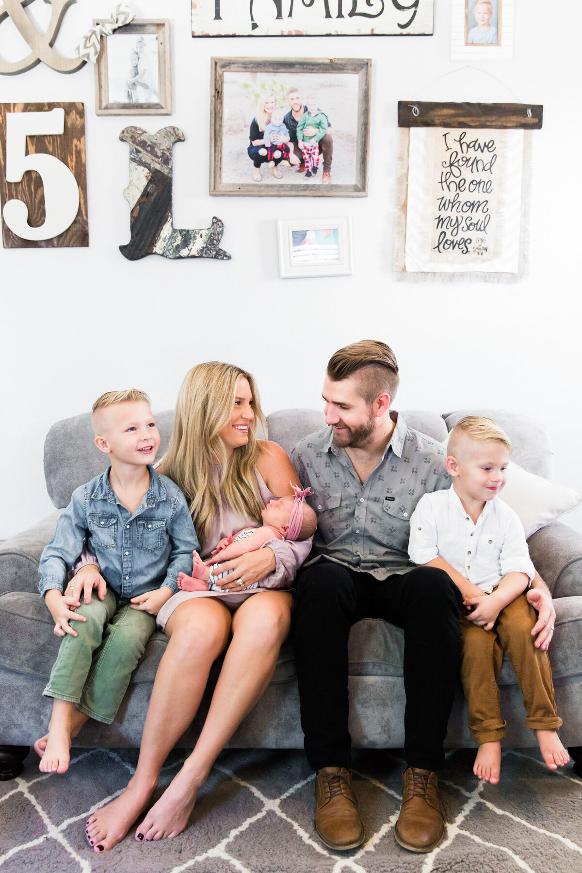 family smiling together with newborn baby