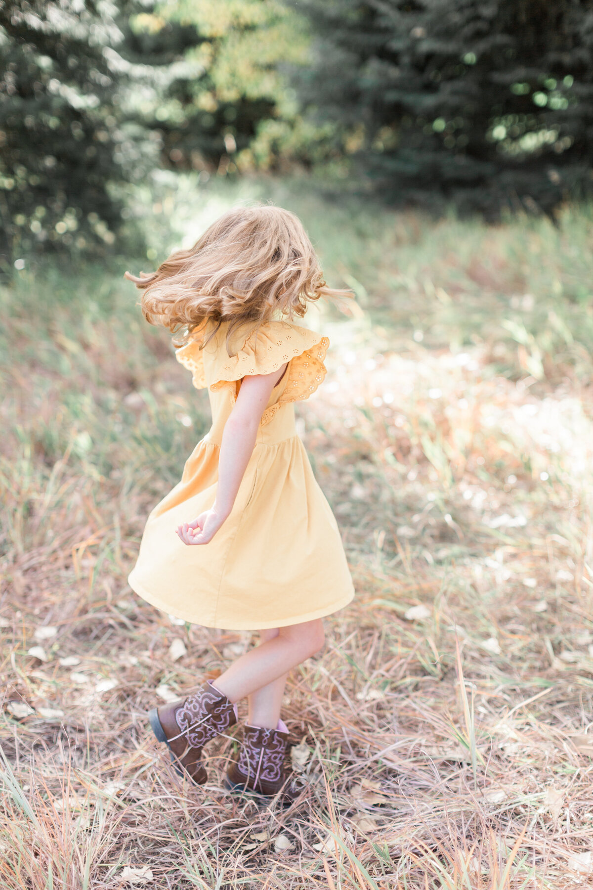 Little girl twirling during her family session in Denver
